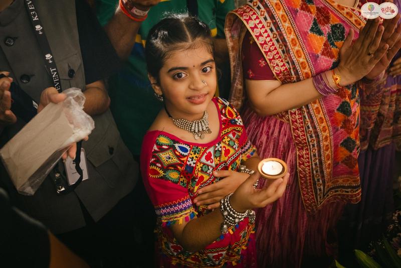 Young girl holding a diya during aarti at Surbhi Dhoom Dandiya 2025