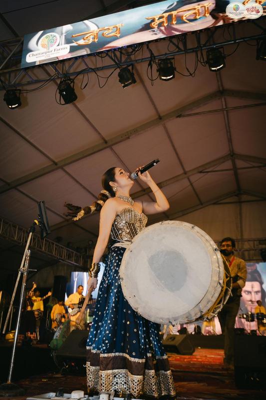 Singer with dhol drum on stage at Surbhi Dhoom Dandiya 2025
